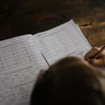 boy writes on his book on the desk